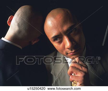 Stock Image - Two bald headed businessmen against each other's head, Front View, Rear View. Fotosearch