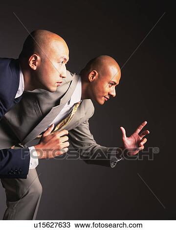 Stock Image - Two bald headed businessmen running, Side View. Fotosearch