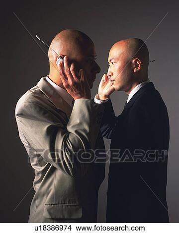 Two bald headed businessmen talking on mobile phones, Side View View Large Photo Image Picture - Two bald headed businessmen talking on mobile phones, Side View. Fotosearch