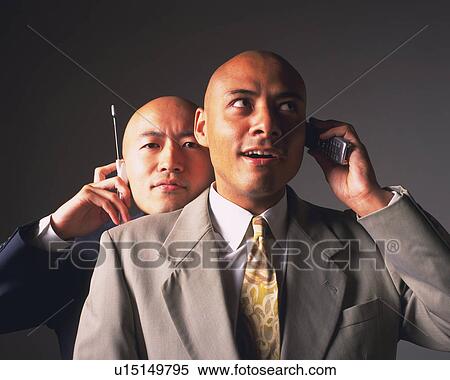 Stock Photography - Two bald headed businessmen talking on mobile phones, Front View. Fotosearch