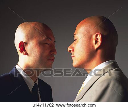 Two bald headed businessmen with eyes closed standing face to face, Side View View Large Photo Image Stock Image - Two bald headed businessmen with eyes closed standing face to face, Side View. Fotosearch