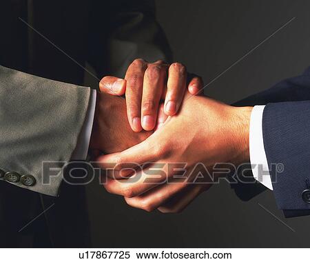 Stock Photography - Two businessmen shaking hands, Side View. Fotosearch