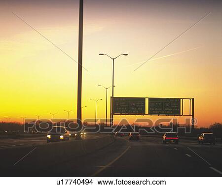 a Highway By Sunset, Several Cars Driving on It View Large Photo Image Picture -  a Highway By Sunset, Several Cars Driving on It. Fotosearch