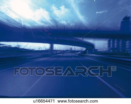 Stock Image -  a Highway Under a Blue Sky, Front View, Blurred Motion, Toned Image. Fotosearch