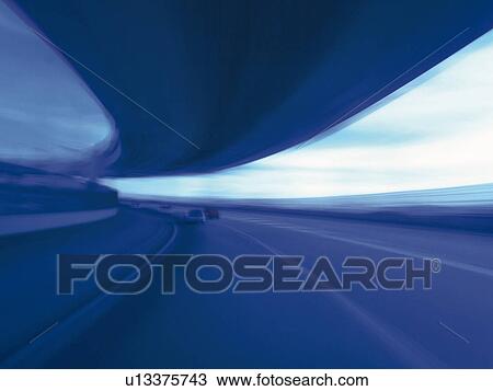 Stock Image -  a Highway, Under a Light Blue Sky, Blurred Motion, Toned Image. Fotosearch