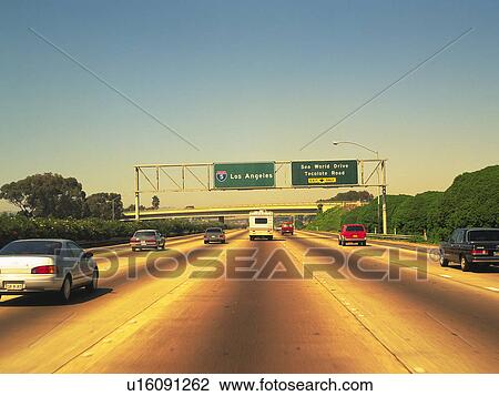 Stock Image -  a Highway With Several Cars Driving on it, Under a Blue Sky, Front View. Fotosearch