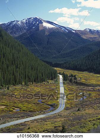 Stock Photo -  a Little Mountain Path, Surrounded By a Forest and Mountains, High Angle View. Fotosearch