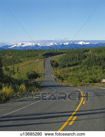 Stock Image -  a Long Road, Heading To Several Snowy Mountains, High Angle View. Fotosearch