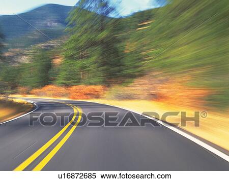 Stock Photography -  a Mountain Path, Surrounded By Several Green and Autumn-colored Trees, Blurred Motion. Fotosearch