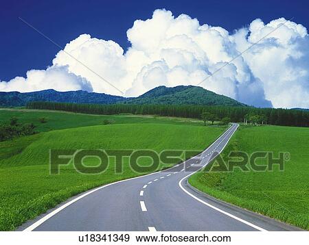 Stock Photo -  a Road, Surrounded By a Huge Flat Grassland Under a Blue Sky, High Angle View, Hokkaido Prefecture, Japan. Fotosearch
