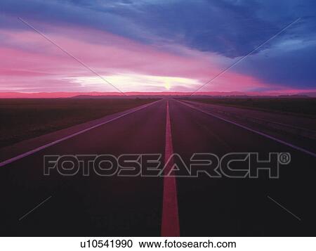 Stock Image -  an Asphalt Road By Sunset, the Sky Pink and Purple From the Setting Sun, Front View. Fotosearch