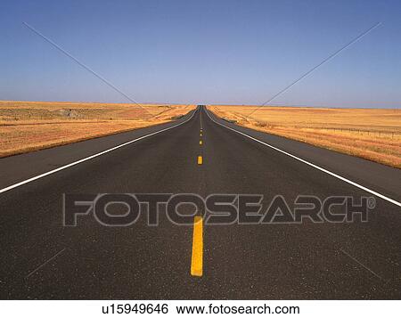 Stock Photograph -  an Asphalt Road, Surrounded By a Huge Flat Land Under a Blue Sky, Front View. Fotosearch