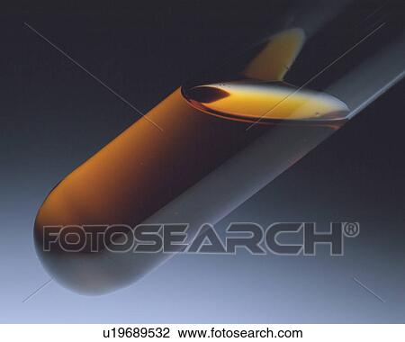 Stock Image -  a Some Brown-colored Oil in a Small Measuring Glass, Side View. Fotosearch