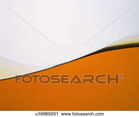 Stock Image - Brown-colored Liquid, Making a Wave. Fotosearch