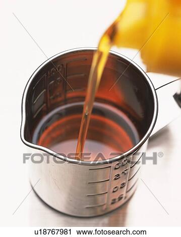 Brown Oil Being Poured Into a Silvern Measuring Cup, High Angle View, Differential Focus View Large Photo Image Stock Image - Brown Oil Being Poured Into a Silvern Measuring Cup, High Angle View, Differential Focus. Fotosearch