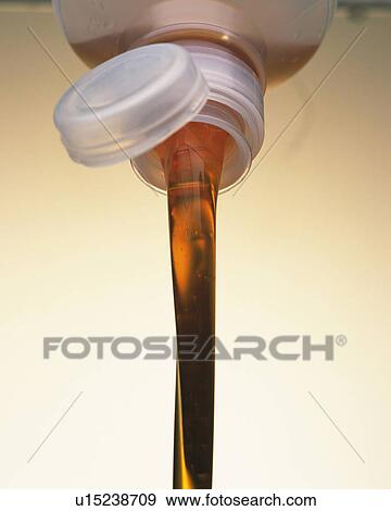 Stock Photo - Brown Oil, Flowing Out of a Plastic Bottle, Low Angle View. Fotosearch