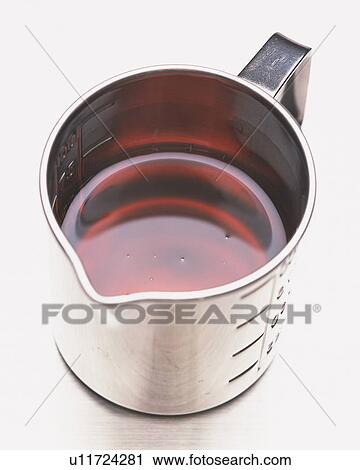 Brown Oil in a Silvern Cup, Standin on a White Surface, High Angle View View Large Photo Image Stock Image - Brown Oil in a Silvern Cup, Standin on a White Surface, High Angle View. Fotosearch