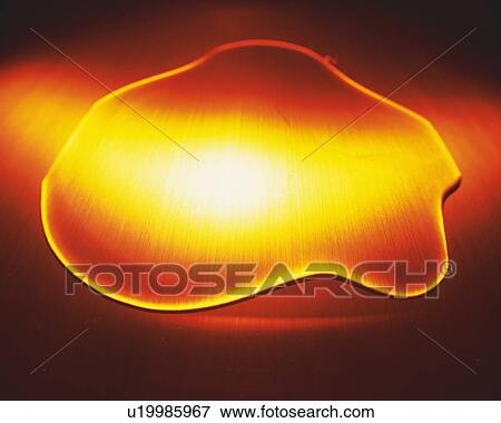 Stock Photo - Green-colored Oil, Being Poured in a Silvern Spoon, High Angle View. Fotosearch