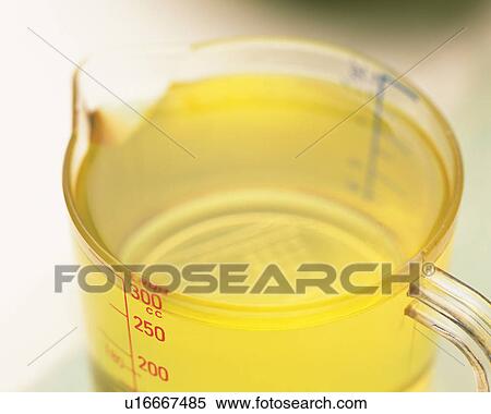 Stock Photography - Light Yellow-colored Oil in a Measuring Cup, High Angle View, Differential Focus. Fotosearch