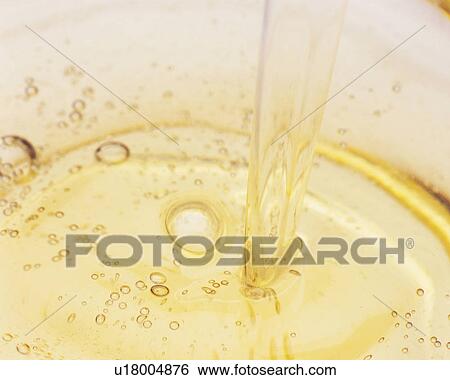 Light-Yellow Oil Being Poured Into a Flask, Making Bubbles, High Angle View View Large Photo Image Stock Photograph - Light-Yellow Oil Being Poured Into a Flask, Making Bubbles, High Angle View. Fotosearch