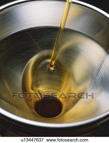 Stock Photo - oil Being Poured Into a Silvern Funnel, High Angle View. Fotosearch