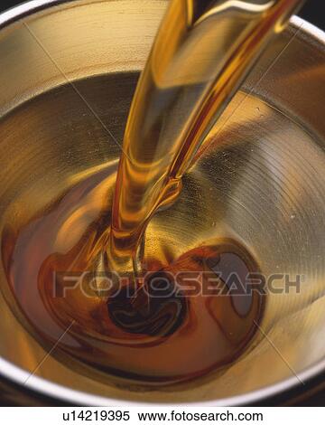 Stock Photography - Orange Oil Being Poured Into A Silvern Funnel, High Angle View. Fotosearch