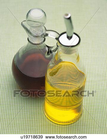 Stock Photo -  Two Different-formed Bottles, One Containing Yellow-colored Oil, the Other Brown-colored Oil, High Angle View. Fotosearch