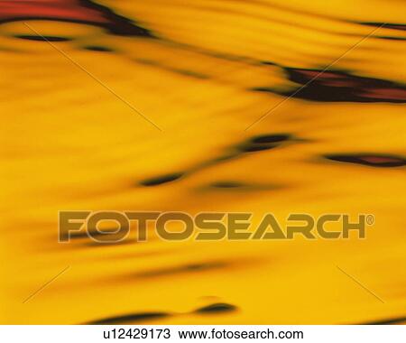 Stock Image - Yellow-colored Liquid Making Waves. Fotosearch