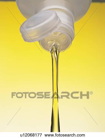 Stock Photo - yellow Oil Flowing Out of a Plastic Bottle, Low Angle View. Fotosearch