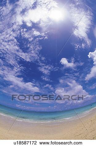 Stock Image -  a Beach and the Ocean Under a Blue Sky, Fish Eye, Lens Flare. Fotosearch