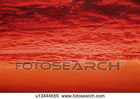 Stock Photography -  a Beach and the Sky, Red From the Setting Sun, Front View, Toned Image. Fotosearch