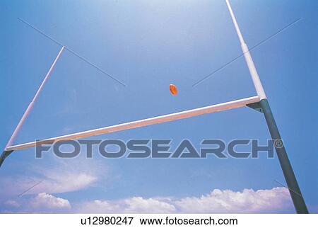 a Rugby Ball Flying Over Its Goal Under a Blue Sky, Low Angle View View Large Photo Image Stock Photo - a Rugby Ball Flying Over Its Goal Under a Blue Sky, Low Angle View. Fotosearch