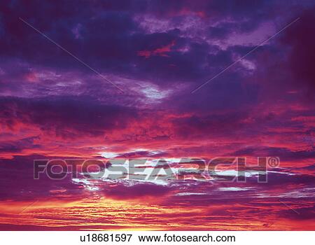 Stock Photo -  a Sea of Clouds, Multicolored From Its Reflection of the Sun, Low Angle View. Fotosearch