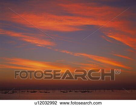 Stock Image -  an Evening Sky, the Clouds Red From the Sunset, Low Angle View. Fotosearch