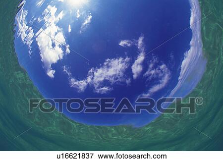 Stock Photo -  Several Clouds Floating in a Blue Sky, Formed as a Ball, Fish Eye. Fotosearch