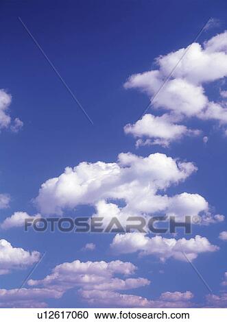 Stock Image -  Several Clouds Floating in the Blue Sky, Low Angle View. Fotosearch