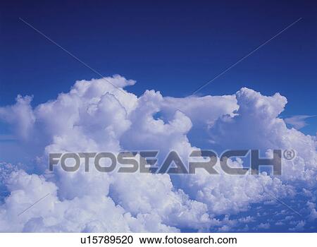 Stock Image -  Several Cumulus Clouds Under a Blue Sky, High Angle View. Fotosearch