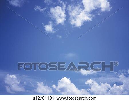 Stock Image -  Several White Clouds Floating in the Blue Sky, Low Angle View. Fotosearch