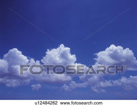 Stock Image -  Several White Clouds in the Blue Sky, Low Angle View. Fotosearch