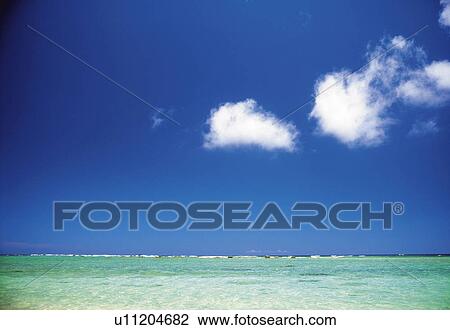 Stock Image -  the Ocean and Its Light Blue-colored and Transparent Water Under a Blue Sky, Front View. Fotosearch