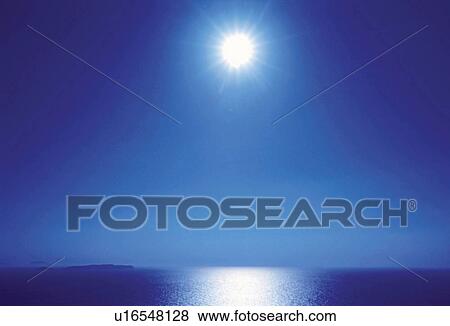 Stock Photo -  the Sun, Shining Over the Ocean, the Water Reflecting the Light, Low Angle View, Lens Flare. Fotosearch