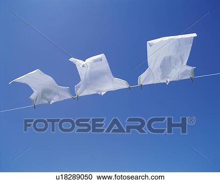 Three White T-shirts Drying Under a Blue Sky, Low Angle View, Copy Space View Large Photo Image Stock Image - Three White T-shirts Drying Under a Blue Sky, Low Angle View, Copy Space. Fotosearch