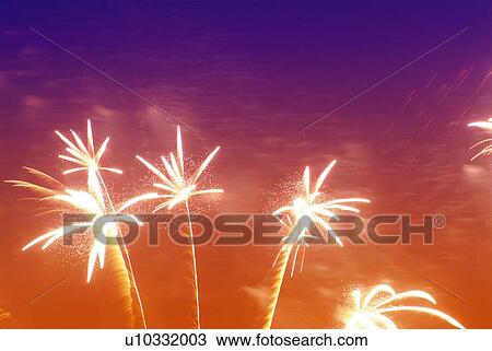 Stock Image - Fireworks exploding in sky, low angle view, long exposure. Fotosearch