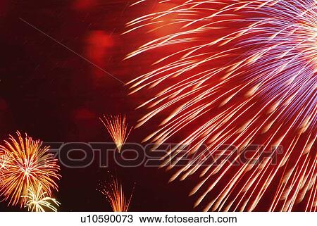 Stock Image - Fireworks exploding in sky, low angle view, long exposure. Fotosearch
