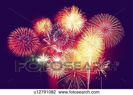Stock Image - Fireworks exploding in sky, low angle view, long exposure. Fotosearch