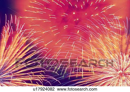 Stock Image - Fireworks exploding in sky, low angle view, long exposure. Fotosearch