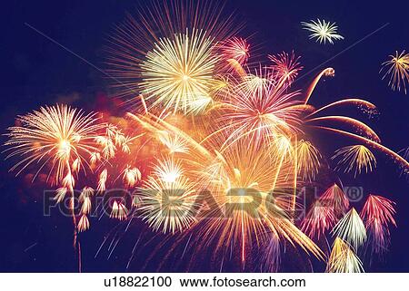 Stock Image - Fireworks exploding in sky, low angle view, long exposure. Fotosearch