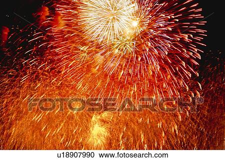 Stock Image - Fireworks exploding in sky, low angle view, long exposure. Fotosearch