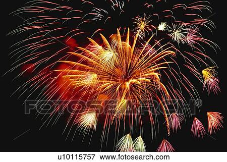 Stock Photo - Fireworks exploding in sky, low angle view, long exposure. Fotosearch