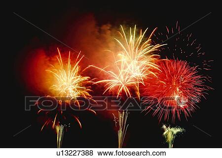Stock Photo - Fireworks exploding in sky, low angle view, long exposure. Fotosearch